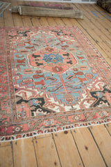 Angled view of vintage Heriz rug's powder blue field, ruby red geometric pomegranate blossoms.