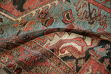 Vintage Heriz rug pile, revealing pomegranate blossoms in ruby red, powder blue, and charcoal.