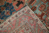 Geometric border and abstract field in ruby red and dusty blue of the vintage Heriz rug.