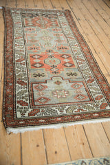 Distressed vintage Malayer runner detail: geometric pomegranate medallions, diamond guls, rust, and silver tones.