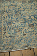 Detailed corner view of a vintage Persian rug's even pile, with geometric motifs in sand and sky blue.
