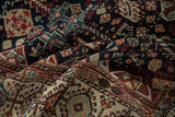 Folded antique Qashqai carpet showing the texture of its intricate tribal motifs and even wear.