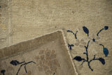 Hand-knotted foundation and visible knot heads beneath beige pile with cobalt blue motifs on an antique Peking rug.