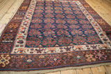 Antique Kurdish rug corner: geometric chocolate brown, ivory borders, and cobalt blue boteh field.