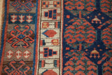 Antique Kurdish rug's geometric banded borders, showcasing cobalt blue, copper, and ivory patterns.