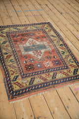 Antique Kazak rug's brick red field with geometric crab and pinwheel motifs, showing yellow border.