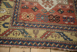 Antique Kazak rug with yellow ground main border featuring serrated leaf and geometric blue patterns.