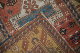 Hand-knotted construction of an Antique Kazak rug, featuring brick red pile and dense yellow foundation.