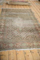 Muted floral pattern with worn side cord on an antique Senneh rug.