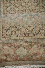 Distressed floral main border and worn fringe of the antique Senneh rug, with muted red.