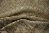 Folds of an antique Malayer rug, displaying distressed texture and faint Herati motifs.