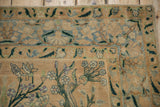Distressed antique Yezd rug corner, with cream, dusty blue, and forest green floral border and checkered blossoms.
