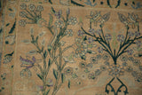 Antique Yezd rug's expressively drawn green vines, purple, blue blossoms on beige field.