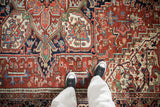 Vintage Heriz carpet with polychromatic geometric blossoms and floral arabesques on brick red.