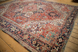 Vintage Heriz rug: navy border, geometric motifs, and unique green spandrels.