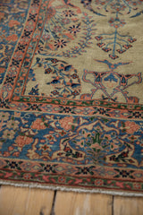 Finely detailed floral vines in sky blue and dusty rose on the sand field of a Farahan Sarouk carpet.