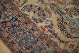 Angled view showing boteh motifs and the detailed floral border of an antique Persian collector rug.