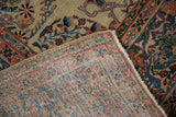 A folded corner reveals the intricate hand-knotted back of an antique Farahan Sarouk carpet.