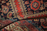 Hand-knotted folds of antique Malayer carpet, with patterns in tomato red, navy, and emerald.