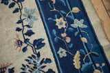 Close view of the wool pile and knot heads forming floral sprays on an antique Peking carpet.