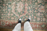 Distressed Karaja carpet's rich jade green and terracotta floral patterns, subtle patina.