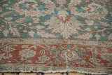 Distressed Karaja carpet close-up, terracotta Samovar Turtle border, with jade green floral motifs.
