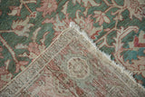 Distressed Karaja carpet corner showing muted green-pink pile, detailed knotted back, and fringe.