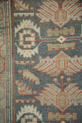 Finned palmettes and serrated leaves showing the even, distressed wear of a vintage Malayer rug.