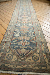 Angled view down the length of a distressed Persian runner with repeating palmettes.