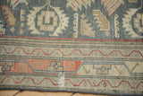 Close-up of a vintage Malayer rug border showing geometric motifs, textured wear, and a small area of restoration.