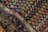 A folded corner shows the low pile and rainbow botehs of a vintage Kurdish Hamadan runner.