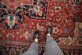 Vintage Heriz carpet detail with serrated leaves and palmettes in gem-tone reds and sapphire blues.