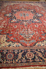 A low-angle view down the vintage Heriz carpet, showing the short pile and gem-toned palmettes.
