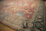 Angled view of an antique Heriz carpet, showing the low, even wear across its elaborate floral arabesques.