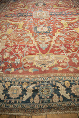 Low pile texture of an antique Heriz carpet, from its navy floral border to the spacious red field.
