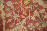 Close-up of the antique Heriz carpet's textured wool pile, with visible knot heads and heavy color abrashes.