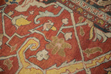 Close view of an antique Heriz carpet's weave showing time-softened colors and large floral arabesques.