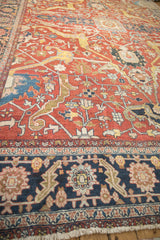 Low-angle view showing the even wear and textured knot heads on an antique Persian Heriz carpet.