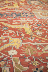 Angled close-up of the antique Heriz carpet showing the low pile and hand-knotted texture.