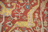 Close-up of a large-scale saffron arabesque and stylized floral motifs on an antique Heriz carpet.