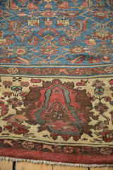 Antique Bakshaish carpet's sapphire blue Herati pattern, cochineal red border, and fringe detail.