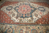 Intricate geometric patterns on an antique Karaja carpet in copper, dusty navy, and beige.