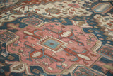 Antique Karaja rug's central stepped medallion, dusty rose, navy, and teal with visible knot heads.