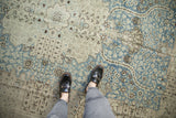 Evenly worn, low-pile texture of a distressed Tabriz carpet in dusty denim blue and charcoal.
