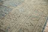 Angled view of the vintage Tabriz carpet's floral border and time-softened low-pile texture.