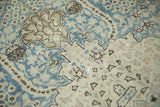 Close-up showing the knot heads and serrated palmette designs of a distressed Tabriz carpet.