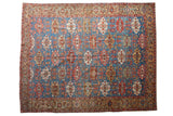 Antique Bakshaish carpet with repeating serrated guls and floral motifs on an aquatic blue field.