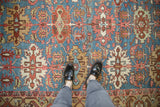 Antique Bakshaish carpet showing serrated guls, floral blossoms, and serrated leaves on blue ground.