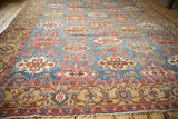 Intricate beige border and sky blue field with repeating serrated guls on antique Bakshaish rug.