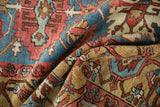 Folded antique Bakshaish rug showing intricate serrated guls, floral patterns, and sky blue abrash.